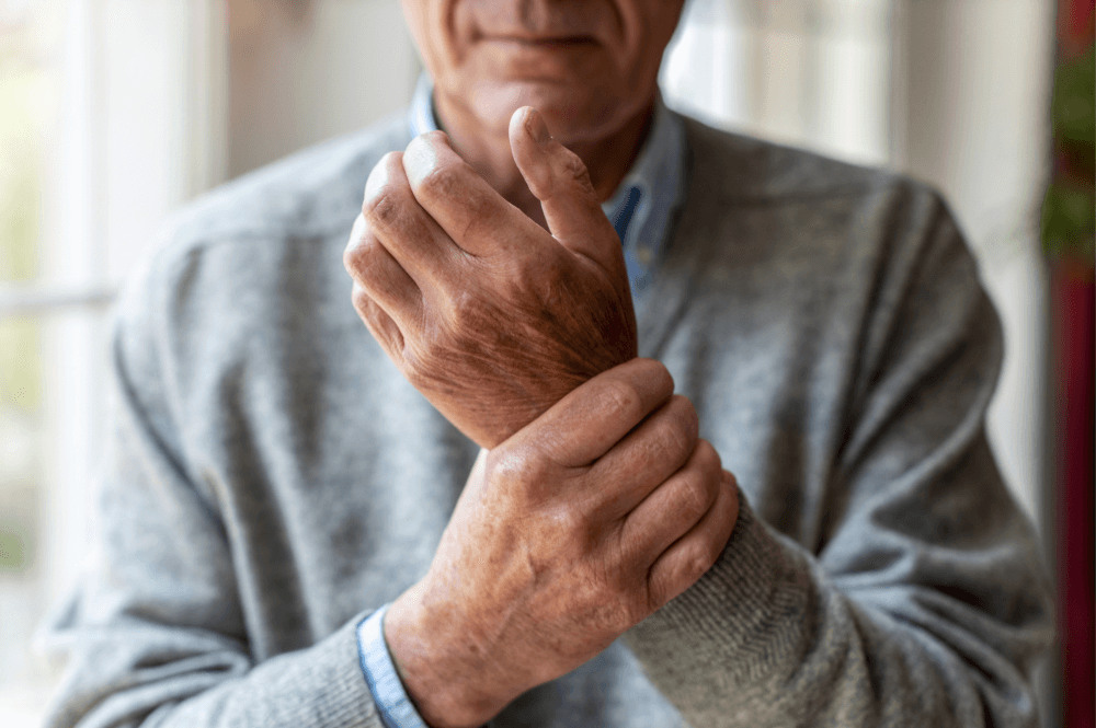 Elderly man holding his wrist due to arthritis pain