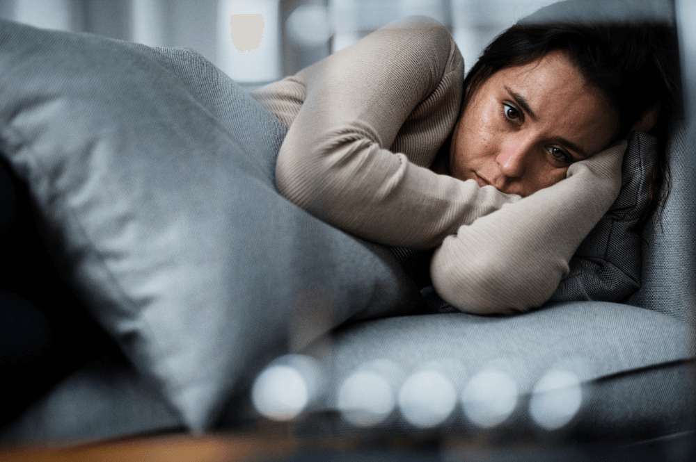 woman laying in bed looking upset
